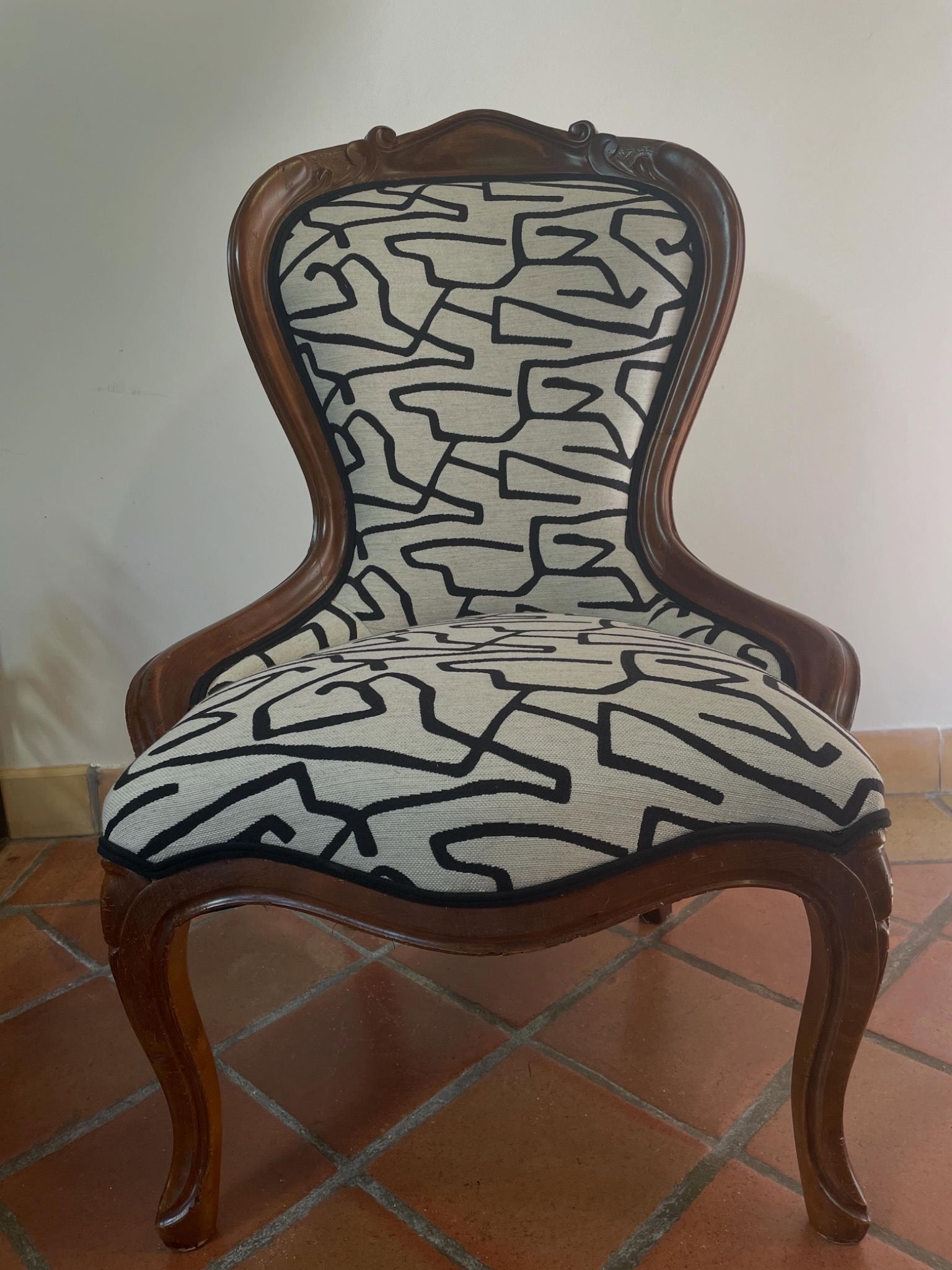 Chauffeuse rénovée avec un tissu graphique noir et écru