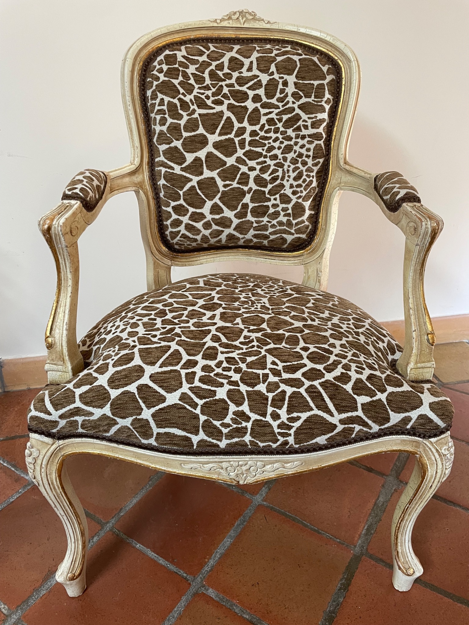 Fauteuil cabriolet ancien rénové avec un tissu imprimé brun et écru