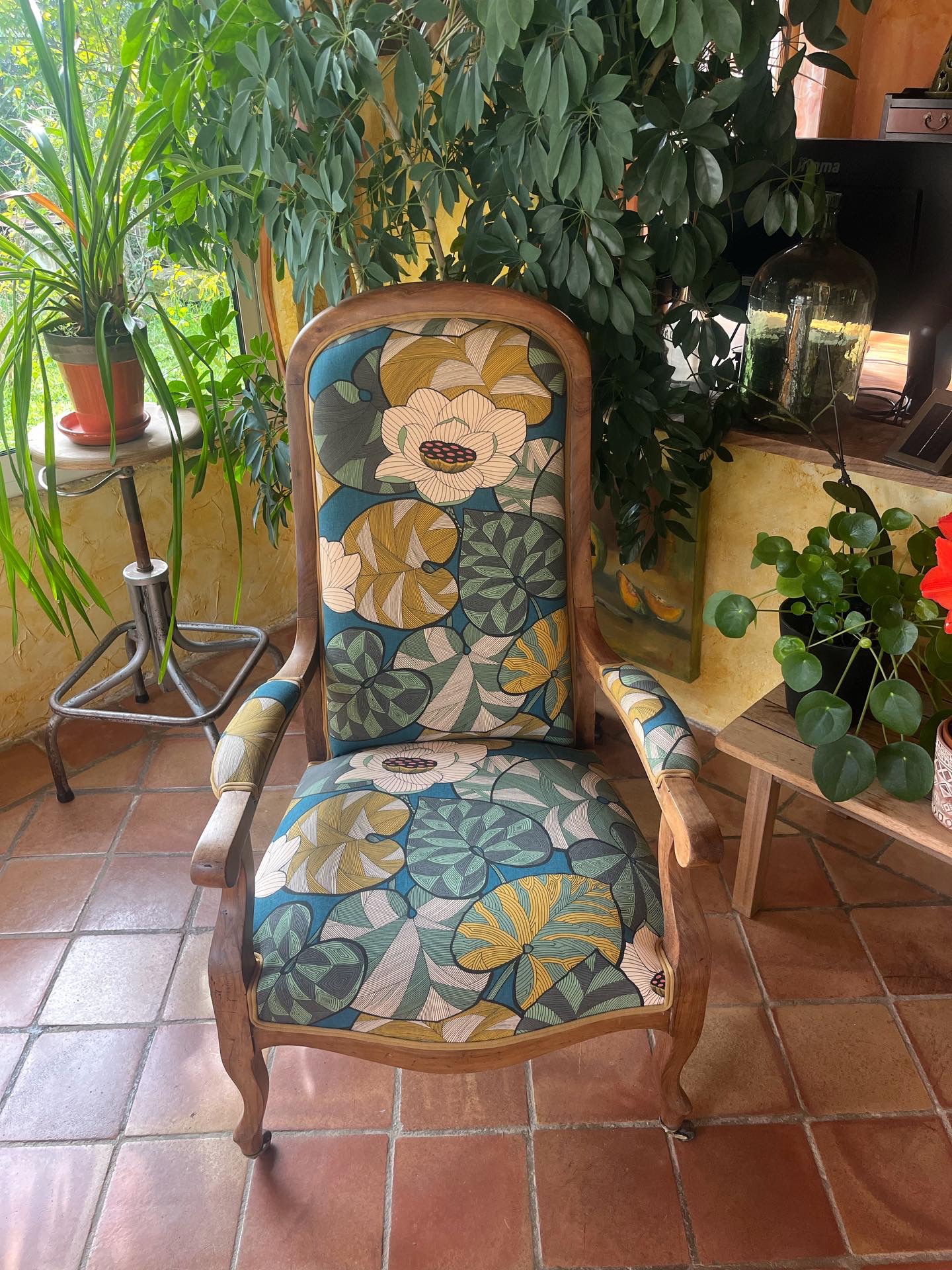 Fauteuil Voltaire en bois avec une assise entièrement refaite et un tissu Thevenon à motifs floraux bleus, verts et jaunes