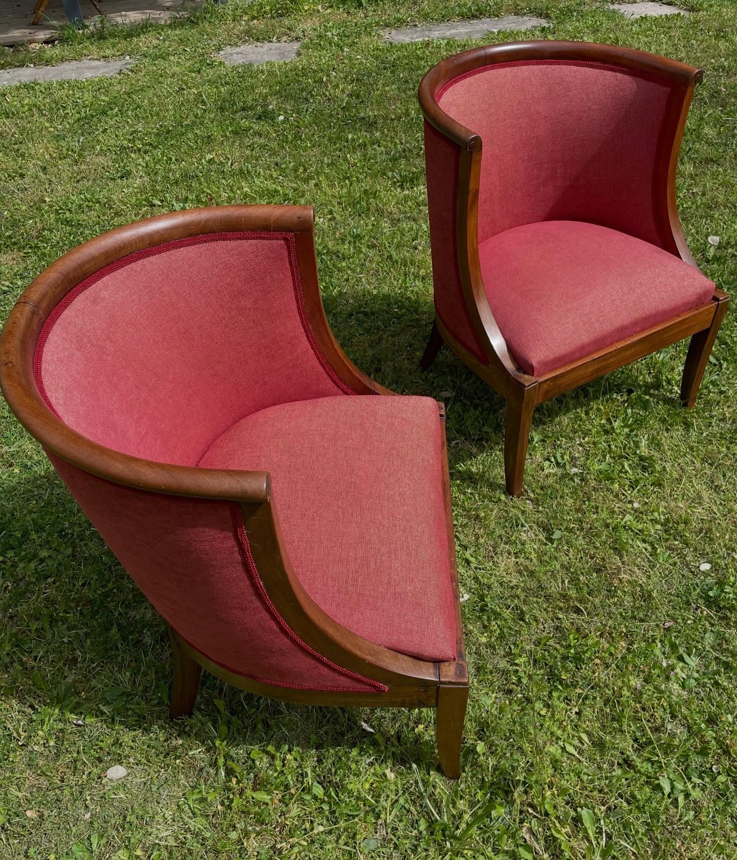 Deux fauteuils gondoles en bois rénovés avec un tissu rouge et une finition en galon assorti